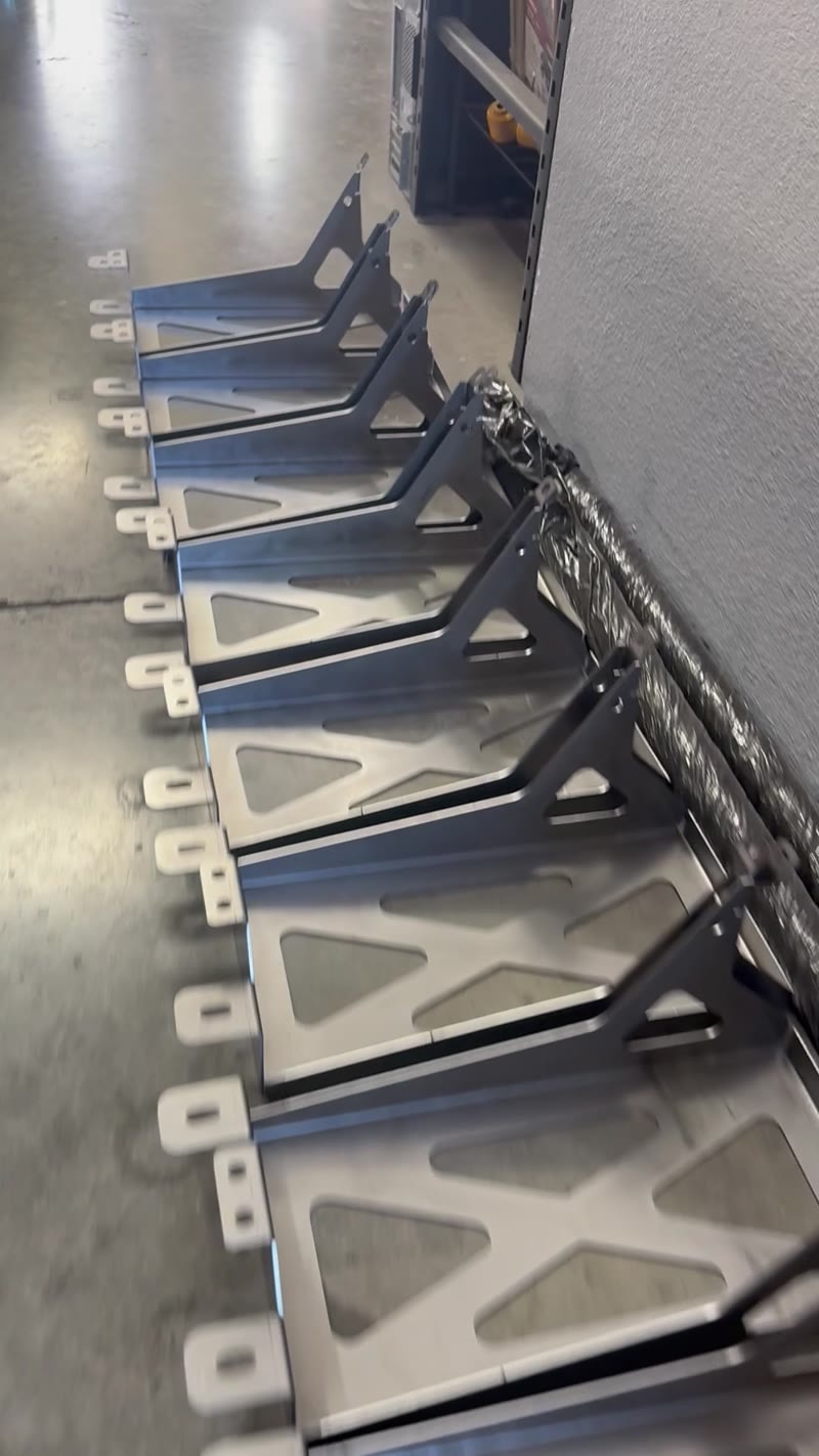 Finished laser-cut steel brackets lined up